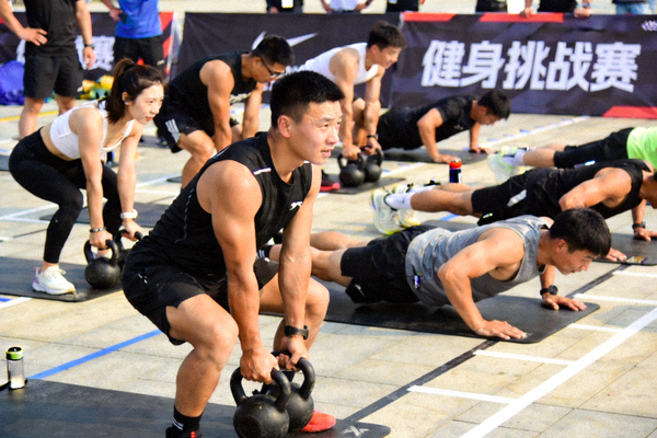 健身挑战赛现场，参与者在进行团体体能训练